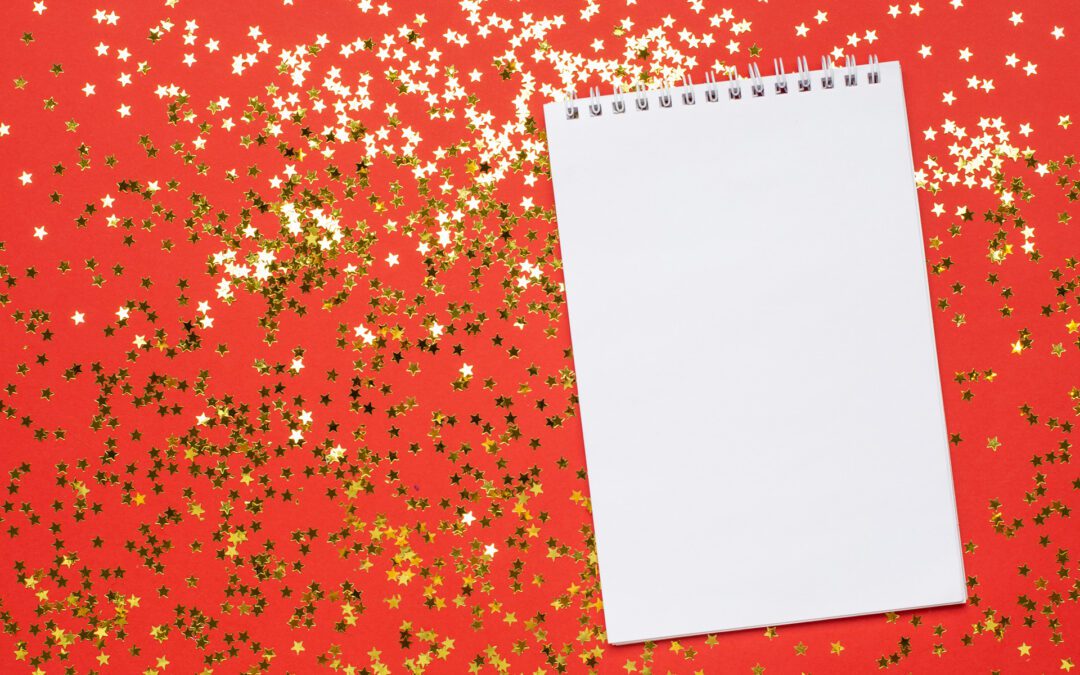 Notebook and golden stars confetti on red color paper background minimal style