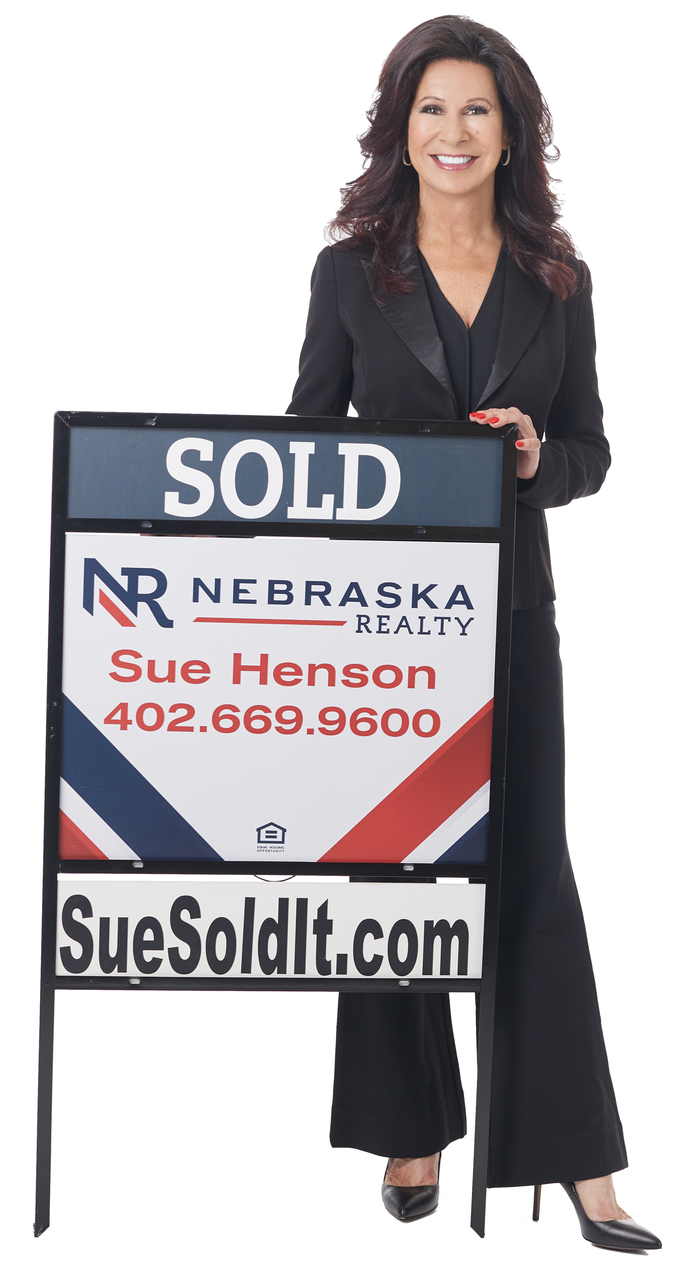 sue henson standing next to her sold sign for Nebraska Realty